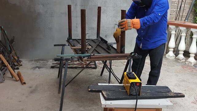 Welder using ceramic tile square tool to check right angle on metal leg