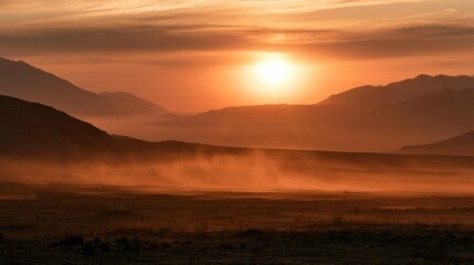 Fototapeta premium Golden hour reveals a warm terracotta haze over the desert landscape and mountains with soft light creating a dreamy effect.