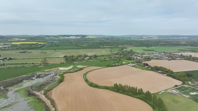 Fields and Farms over Bosham Quay from a drone at low tide, Chichester Harbour National Landscape, Chichester, West Sussex, England