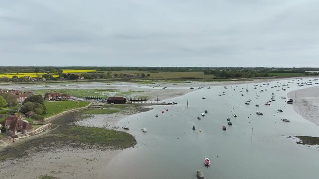 Fields and Farms over Bosham Quay from a drone at low tide, Chichester Harbour National Landscape, Chichester, West Sussex, England