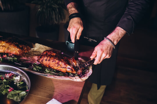 Masterful Carving: A chef skillfully carves a succulent roasted turkey, prepared with herbs and spices, ready to be served at a festive gathering.