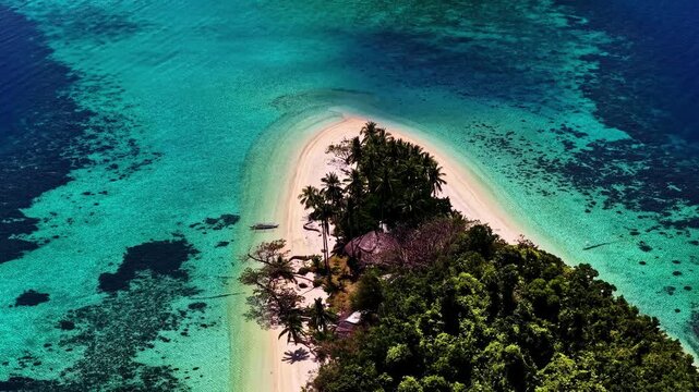Aerial view of Port Barton Beach with turquoise water, coral reefs, and lush palm trees in Mimaropa, Philippines.