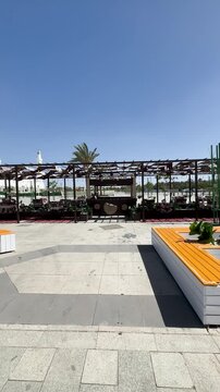 Modern plaza and traditional outdoor seating with a view of Masjid Quba in Medina.