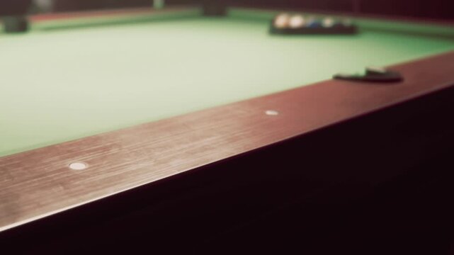 A pool table is shown with colored balls arranged in a triangle at one end. The room is dimly lit, creating a focused atmosphere for playing.