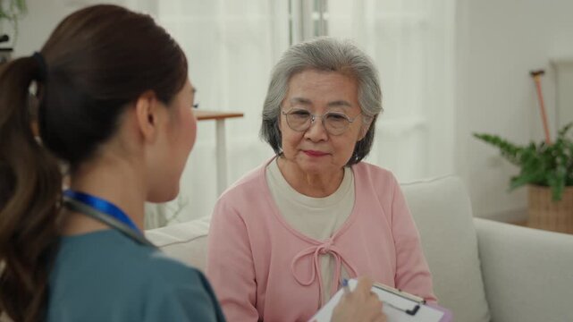 Gentle caregiver nursing home elderly care support senior woman conversation in bright living room with female nurse and home care clinic setting