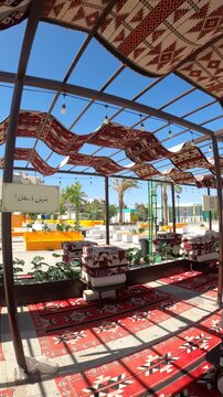 Traditional outdoor majlis seating under a patterned sunshade near Masjid Quba in Medina.