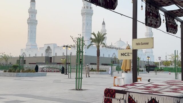 Exterior View of the white Masjid Quba in Medina from an outdoor traditional seating area.