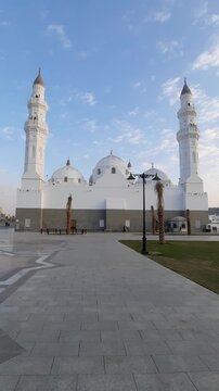 Stunning exterior view of white Masjid Quba in Medina with birds flying.