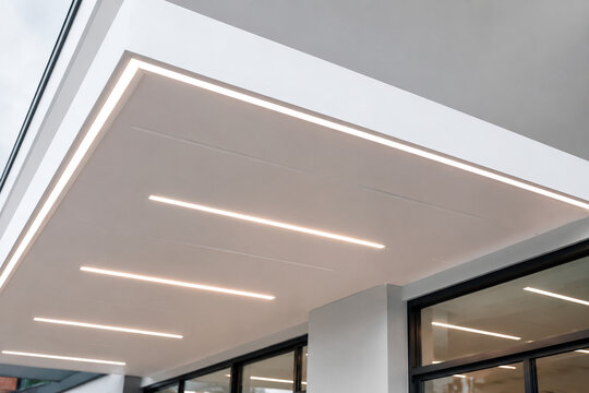 Modern building soffit with recessed linear LED strips in white ceiling.
