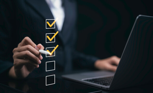 Business professional completing digital checklist with laptop showing task management workflow project planning productivity compliance verification approval organization and business goals