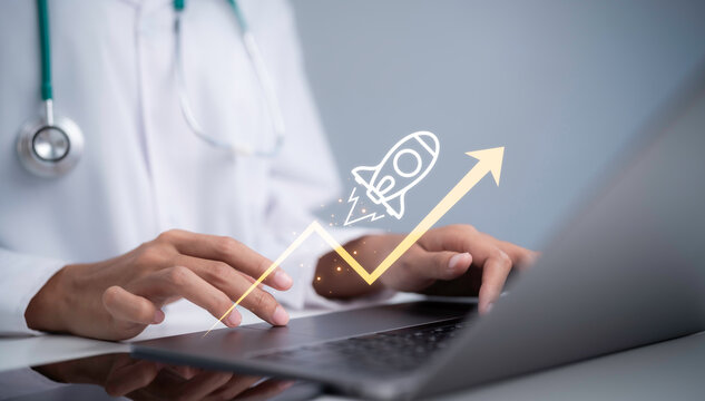 Doctor using laptop with growth arrow and rocket in healthcare setting showing medical technology business growth digital innovation startup success strategy and future development solutions