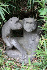 Fototapeta premium Two stone monkey statues in the roadside grass