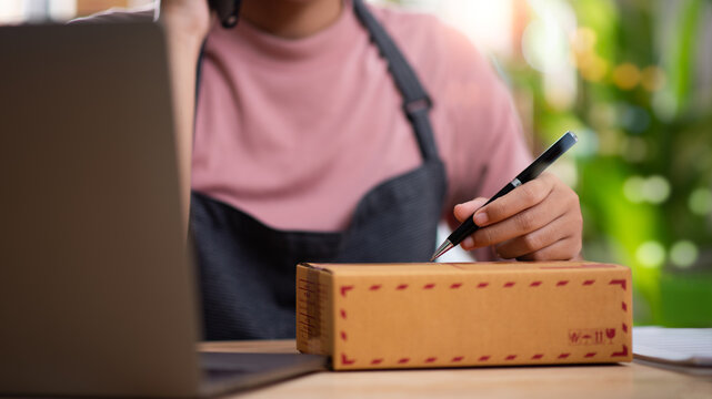 Ecommerce seller prepares a customer parcel for shipping while managing online orders, fulfillment, packaging, delivery, logistics, inventory, and dispatch for an efficient retail operation.