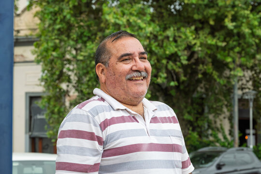 Persona mayor (hombre) abrazando a una joven mientras ambos sonr&iacute;en en un retrato en plano americano. Imagen asociada con afecto intergeneracional, bienestar, acompa&ntilde;amiento, v&iacute;nculos familiares