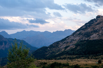 Fototapeta premium A green mountain peak rises under soft evening clouds in the Spanish Pyrenees near Formigal Spain a serene and majestic landscape of the Tena Valley inviting solitude and escape into nature.