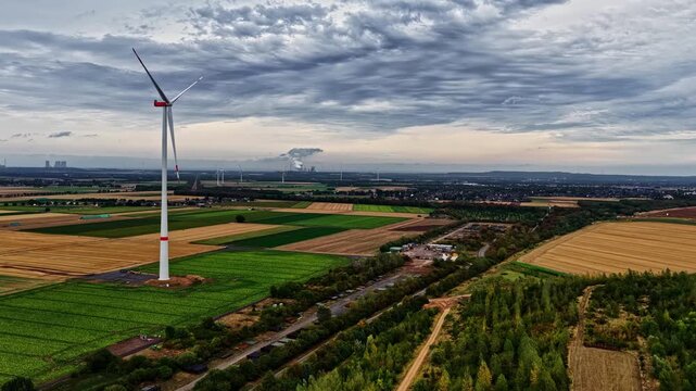 Aerial view of a wind turbine standing in agricultural fields near the Tagebau Hambach open-pit mine in Elsdorf, Nordrhein-Westfalen, Germany.