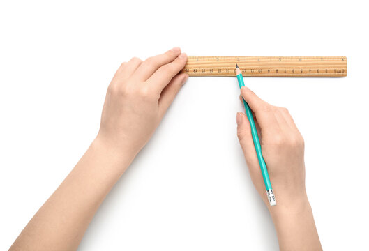 Female hands with ruler and pencil on white background