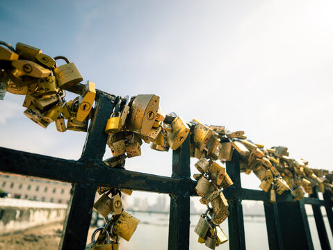 Many old golden love locks attach to a black metal railing