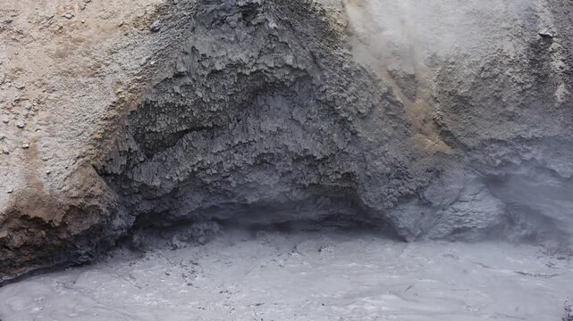 Boiling gray clay in mud pot in Hayden Valley, rocky environment, Yellowstone National Park, summer vacation destination for outdoor nature recreation
