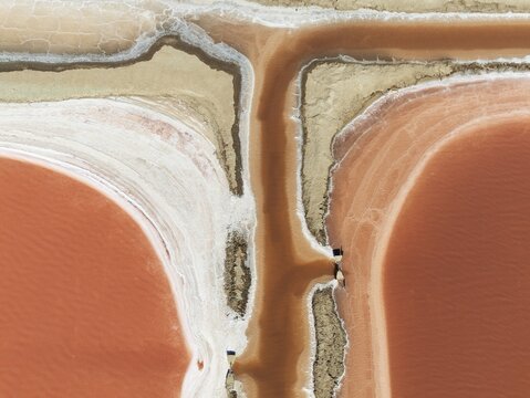 Saline ponds at the Bonanza salt works near Sanl&uacute;car de Barrameda. The reddish colour depends on the level of salinity and is directly caused by the algae Dunaliella salina and brine shrimp. Aerial view. Drone shot. C&aacute;diz province, Andalusia, Spain