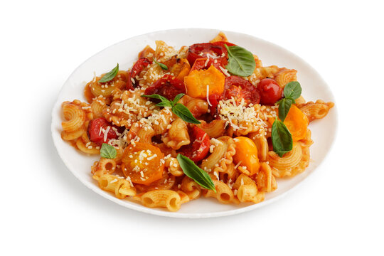 Plate of tasty pasta with tomato and basil on white background