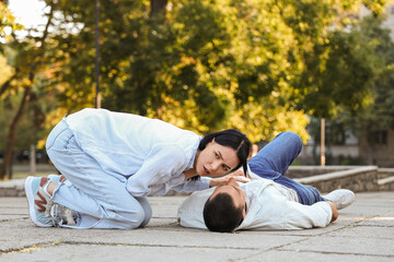 Obraz premium Young woman with her unconscious husband having heart attack on street