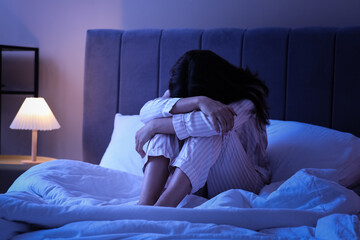 Beautiful young woman suffering from insomnia in bedroom at night