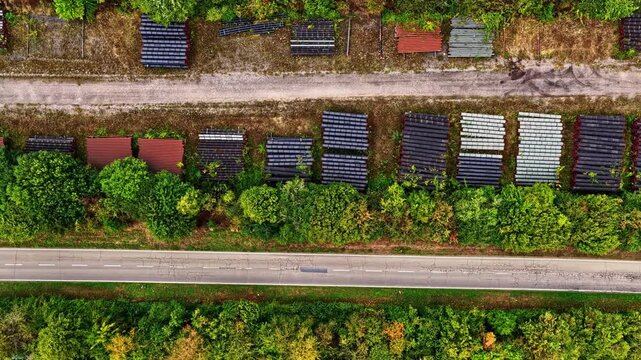 Aerial view of industrial pipes stacked in rows near a road and forest area at Tagebau Hambach in Elsdorf, Nordrhein-Westfalen, Germany.