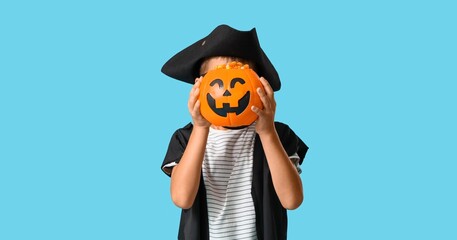 Naklejka premium Halloween celebration and trick or treat, child in pirate costume holding a jack o lantern candy bucket on a blue background