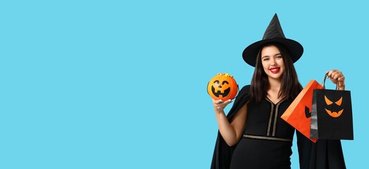 Naklejka premium Halloween shopping and holiday sales, young woman in witch costume holding pumpkin candy bucket and gift bags on blue background