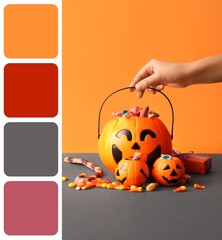 Naklejka premium Halloween celebration and trick or treat tradition, hand holding pumpkin bucket filled with candy and sweets on orange and grey background