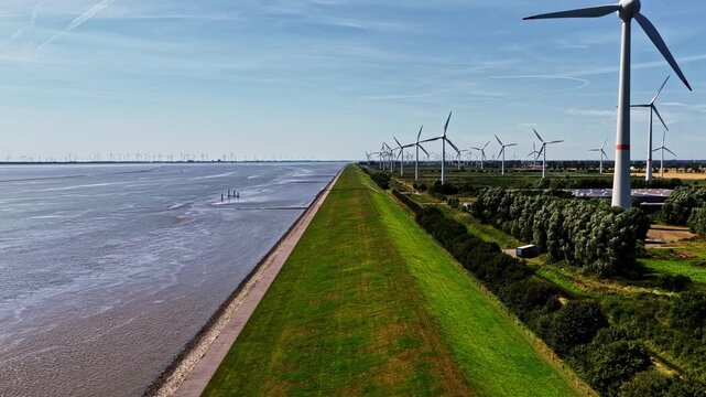 Aerial view of wind turbines along the dike near the Volkswagenwerk Emden factory in Emden, Niedersachsen, Germany.