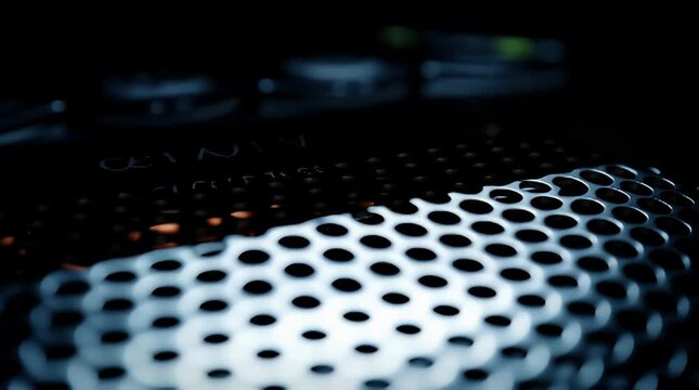 Close-up of a metallic grill with circular perforations creating an abstract pattern against a dark background a modern and industrial texture for design projects