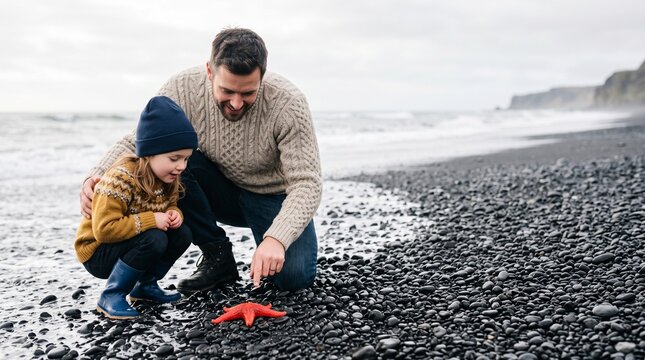 Father and daughter discover red starfish, enjoying cool summer tourism on a black pebble beach