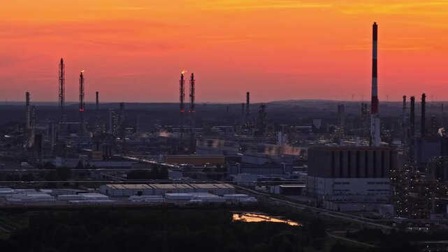 Aerial view of Orlen Plock Production Plant with industrial chimneys and flares at sunset in Plock, Mazowieckie, Poland.