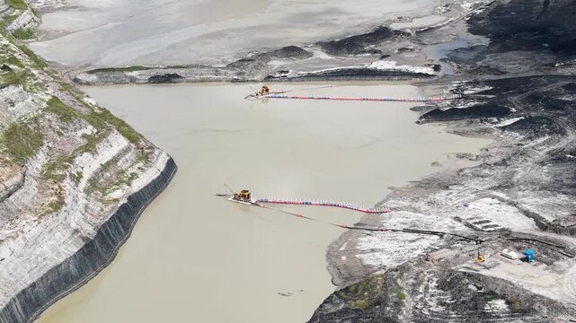 An aerial view of a sludge suction machine extracting mud at a vast and deep coal mine