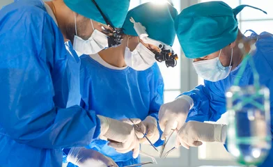 Fotobehang Onderzeeër Surgeon group professional medical doctors surgical team performing serious surgery, operation, procedure on patient in surgical gown, cap, face mask, eye loupe binocular, treat injuries, diseases  © Studio Romantic