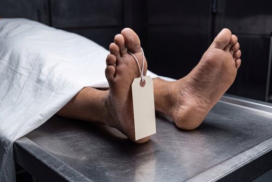 Human feet with a blank identification tag on a mortuary table