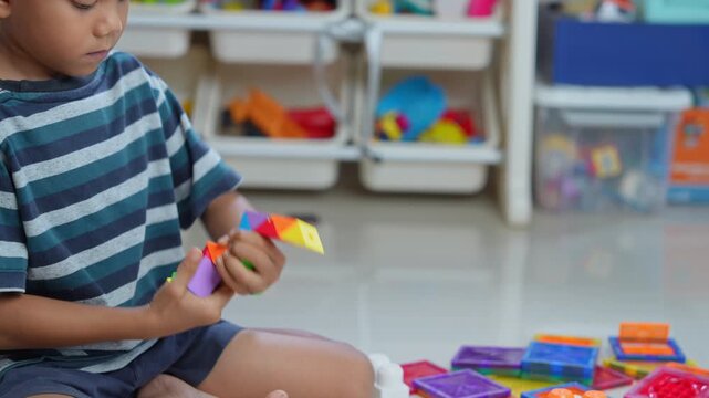 Child playing with colorful plastic building blocks on the floor