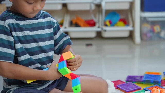 Child playing with colorful plastic building blocks on the floor