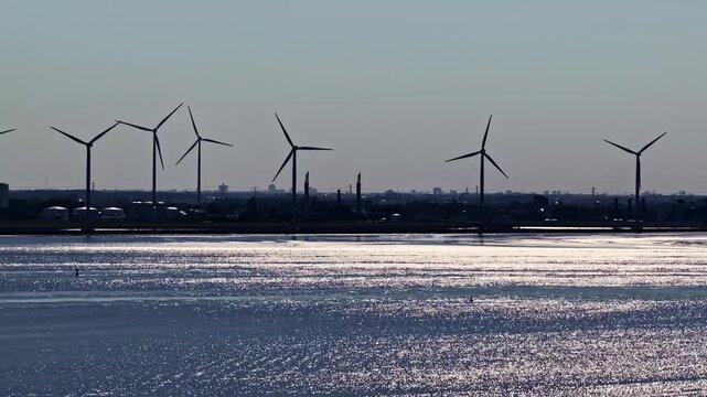 Aerial view of wind turbines standing along the coastline near the Volkswagenwerk Emden factory in Emden, Niedersachsen, Germany.