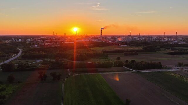 Aerial view of Orlen Plock Production Plant at sunset with industrial chimneys and surrounding fields in Plock, Mazowieckie, Poland.