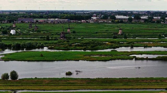 Aerial view of the historic Unesco Werelderfgoed Kinderdijk windmills set amidst lush green polders and winding waterways in Kinderdijk, Zuid-Holland, Netherlands.