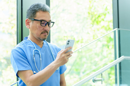 スマートフォンを使う中高年の医師