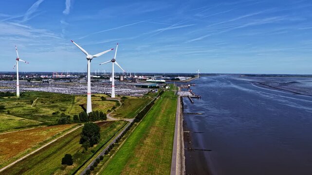Aerial view of the Volkswagenwerk Emden car factory and wind turbines along the Ems river, Emden, Niedersachsen, Germany.