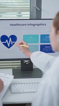 Doctors analyzing healthcare infographics and cardiovascular data on computer screen during clinical discussion and medical research meeting.