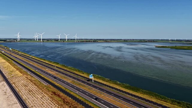 Aerial view of Windpark Fryslan with wind turbines along the Afsluitdijk highway and the IJsselmeer, Breezanddijk, Friesland, Netherlands.