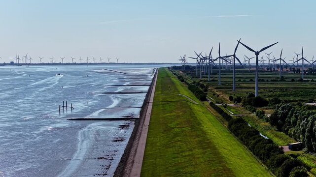 Aerial view of wind turbines along the dike and coastline near the Volkswagenwerk Emden factory in Emden, Niedersachsen, Germany.