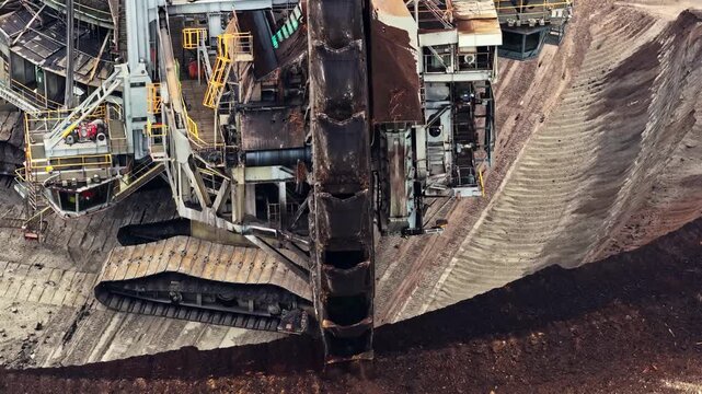 Aerial view of the massive bucket-wheel excavator operating at the Garzweiler surface mine, extracting coal from the deep earth in Juchen, North Rhine-Westphalia, Germany.