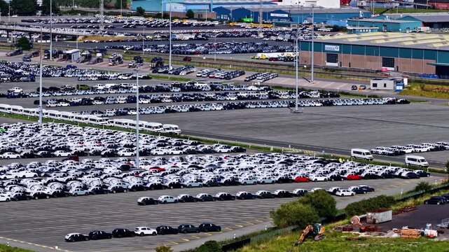 Aerial view of Volkswagenwerk Emden with thousands of new cars parked in rows at the large manufacturing facility in Emden, Niedersachsen, Germany.